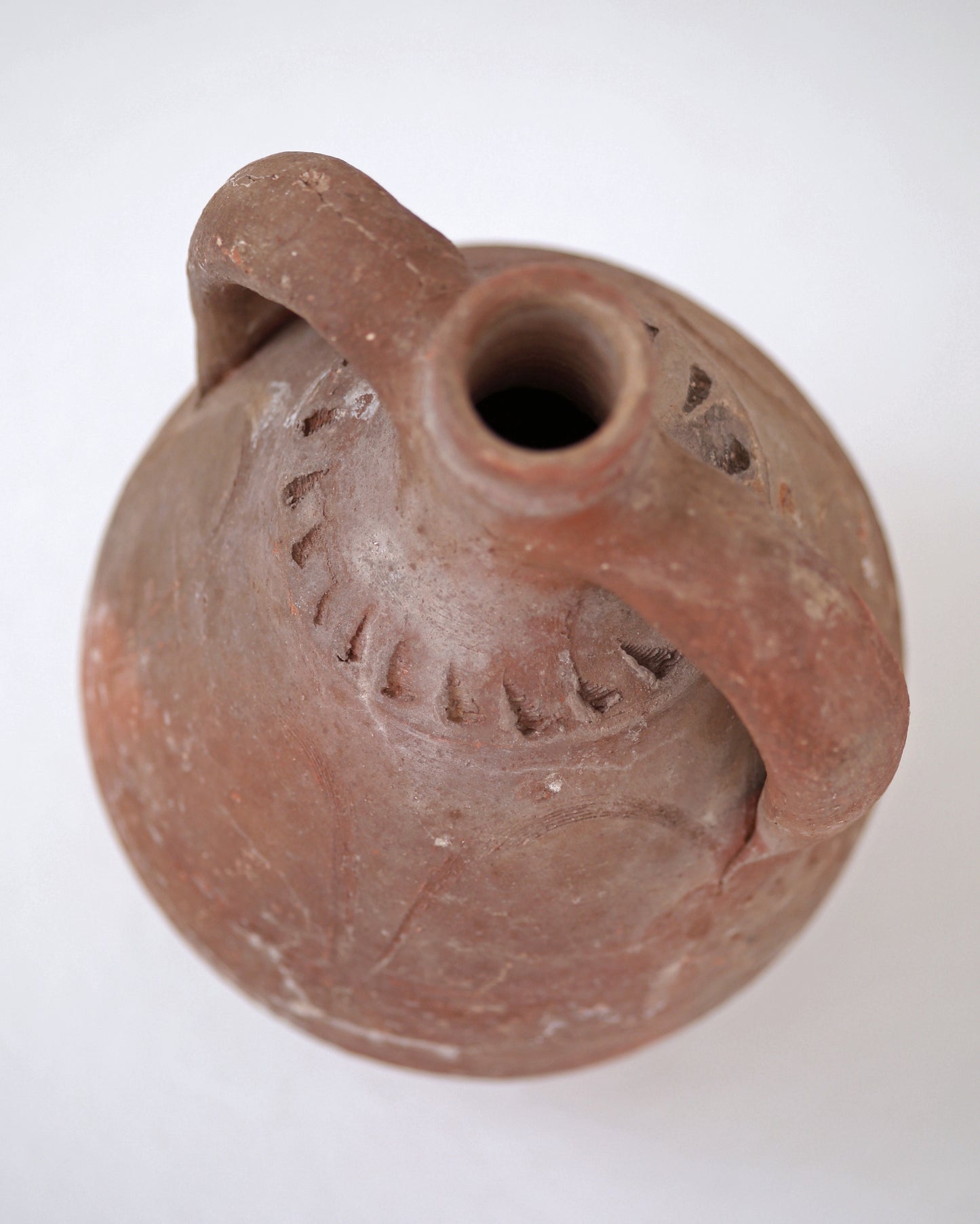 Top view of vintage amphora pot opening and handles decorated with rustic terracotta carvings