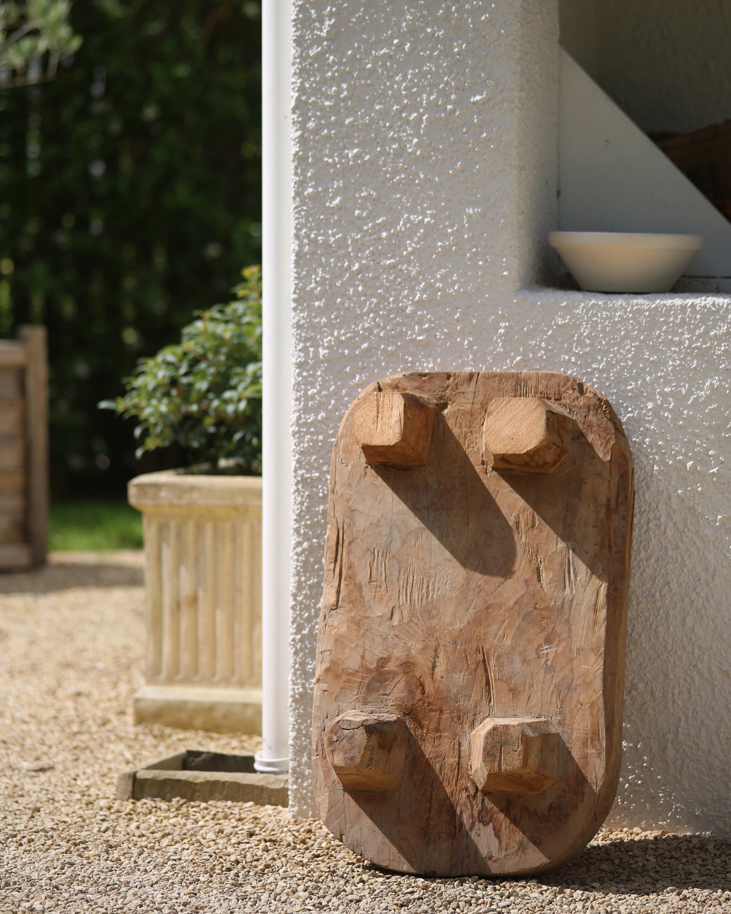 Rustic carved legs of raised wooden serving board for food display