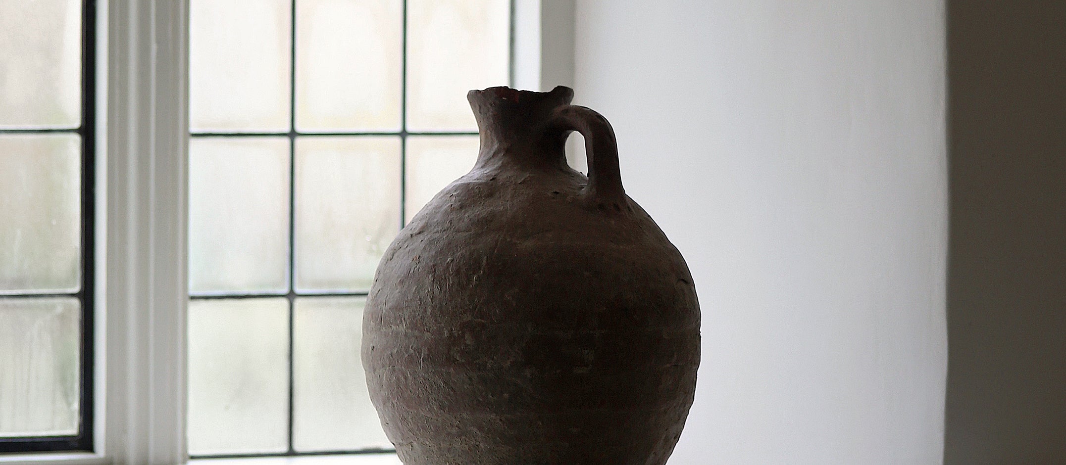 Old textured pot in farmhouse window sill