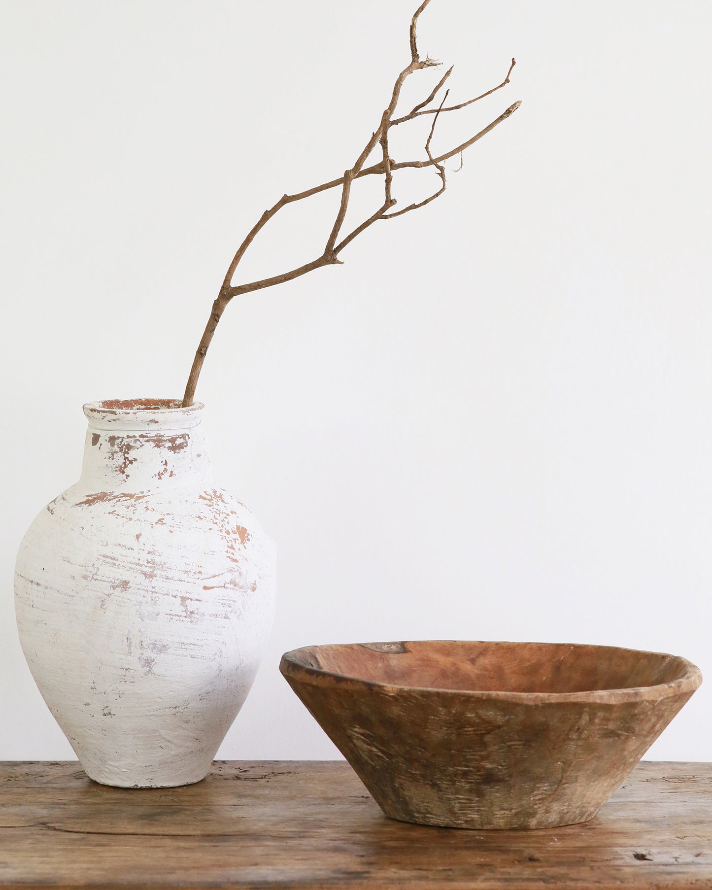 White terracotta vase with wooden styling on coffee table