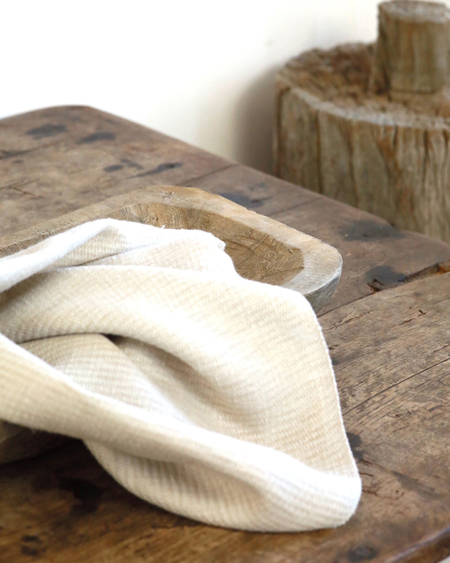Close up of hand carved raw wood tray with cloth
