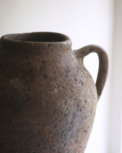 Close up of antique artisan aged clay urn style pottery vase