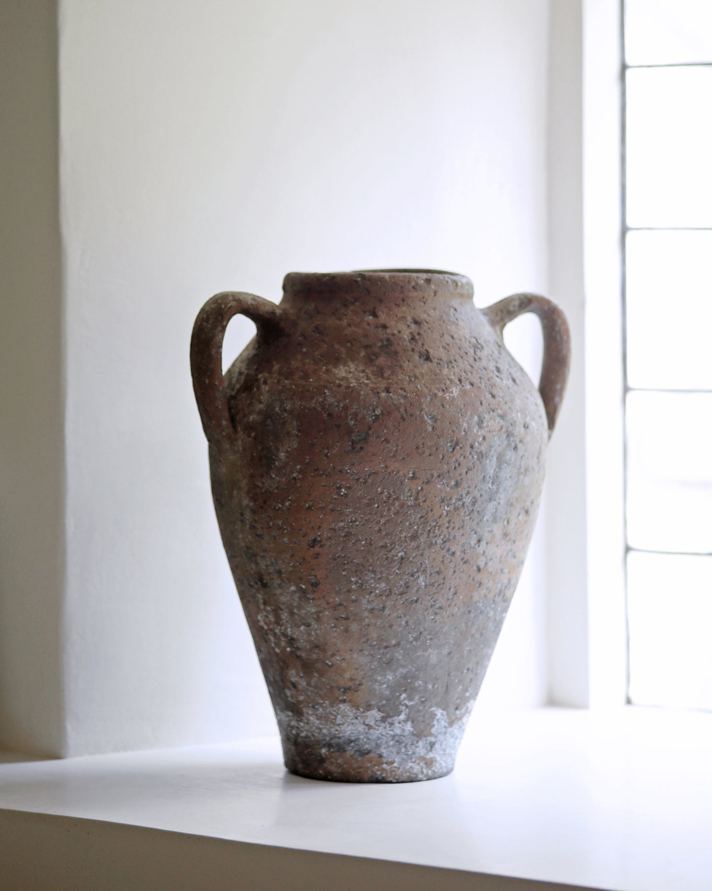 Old pot displayed on farmhouse window sill