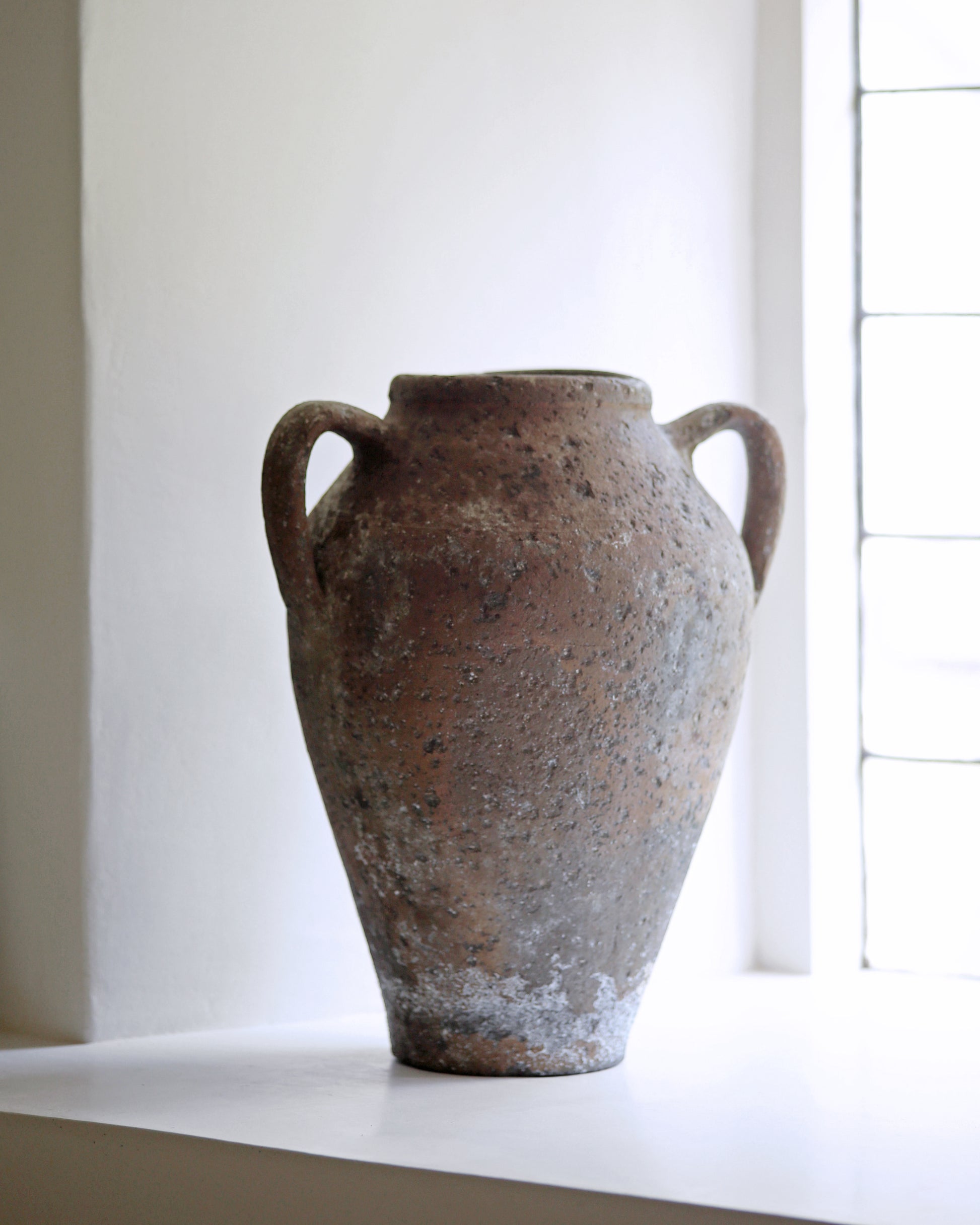 Old pot displayed on farmhouse window sill