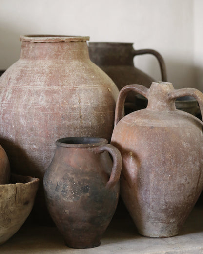 Collection of rustic clay pots on a neutral background