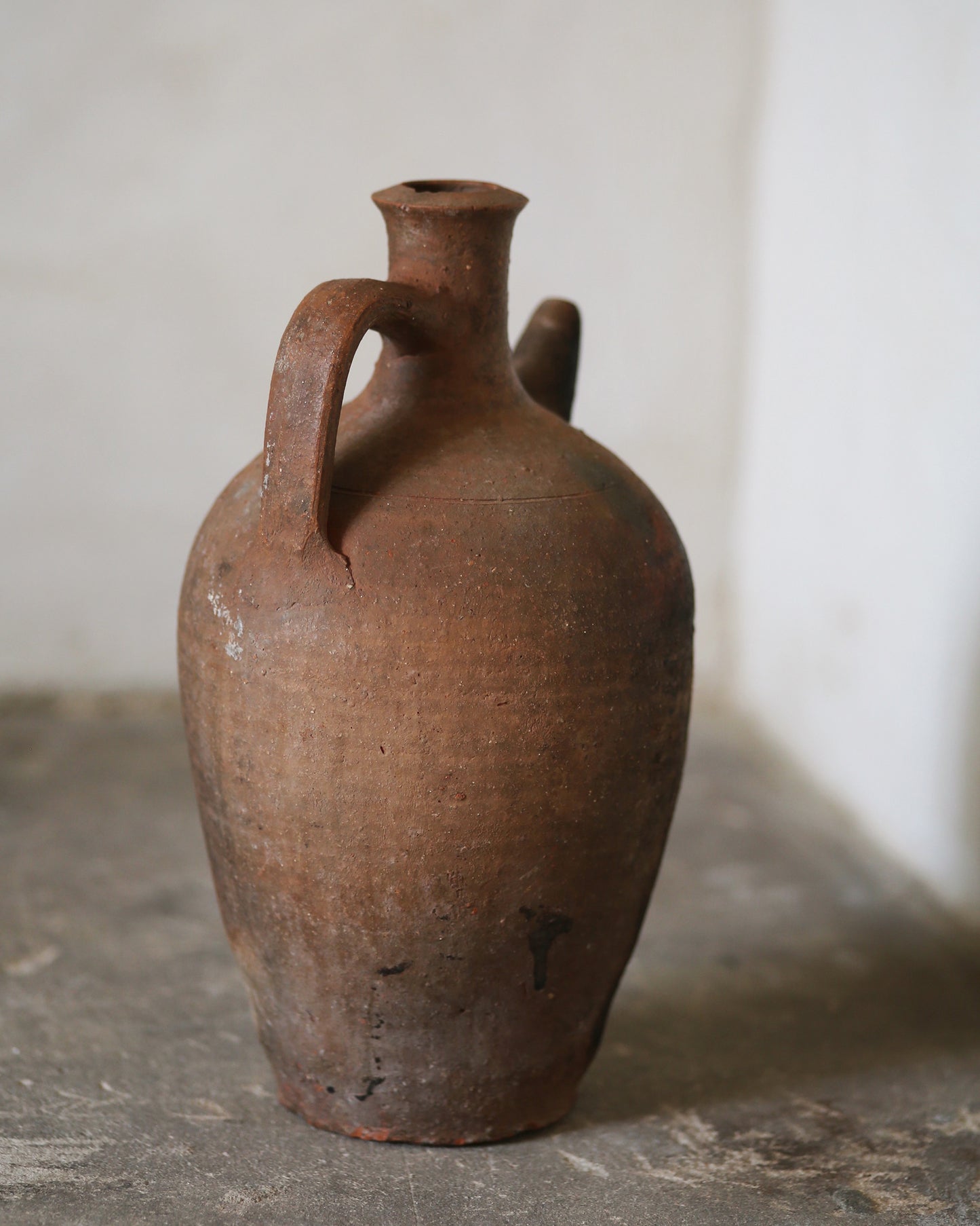 Terracotta amphora jug on flag stone floor