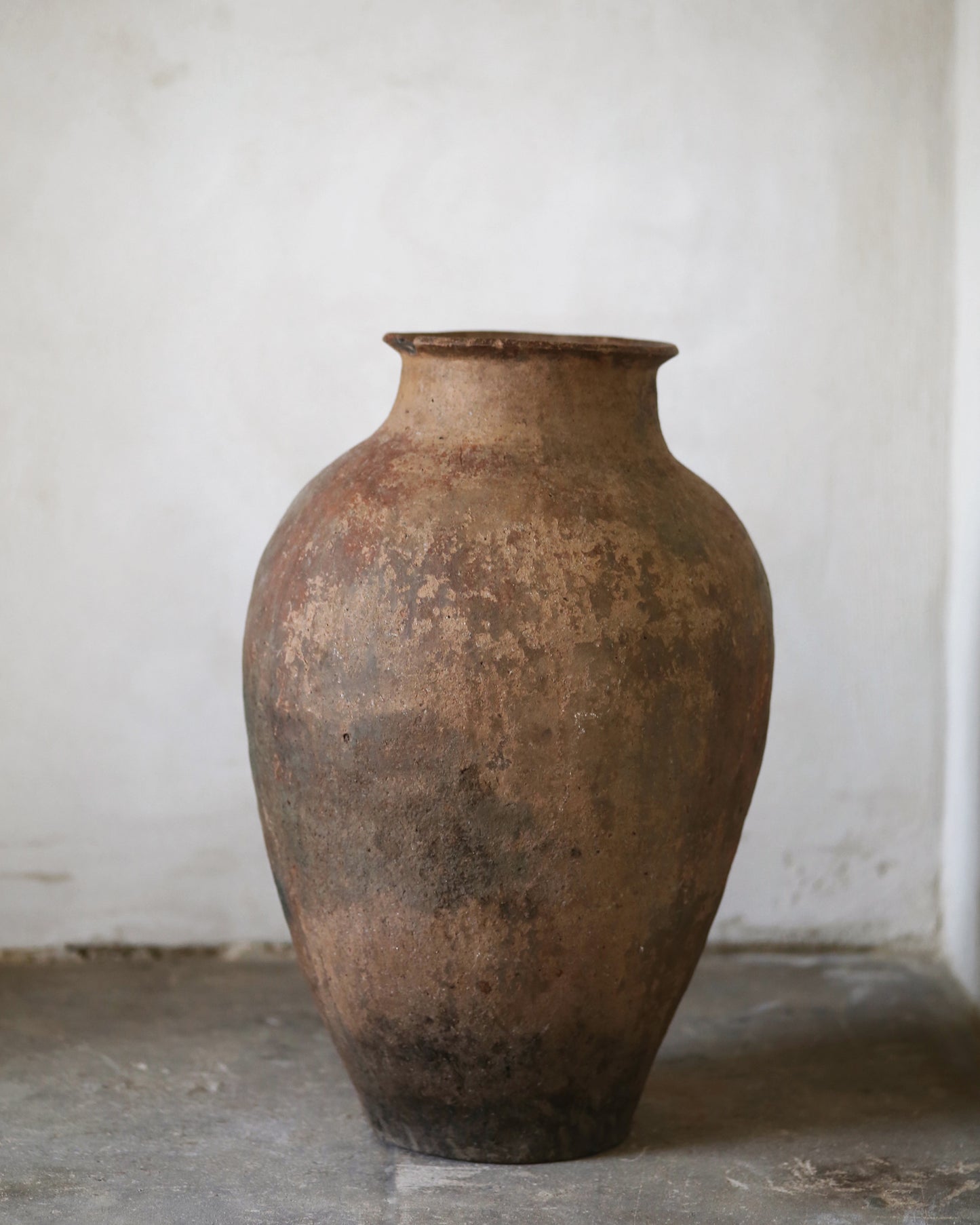 Brown ceramic Turkish terracotta vase on a gray stone floor with a white background