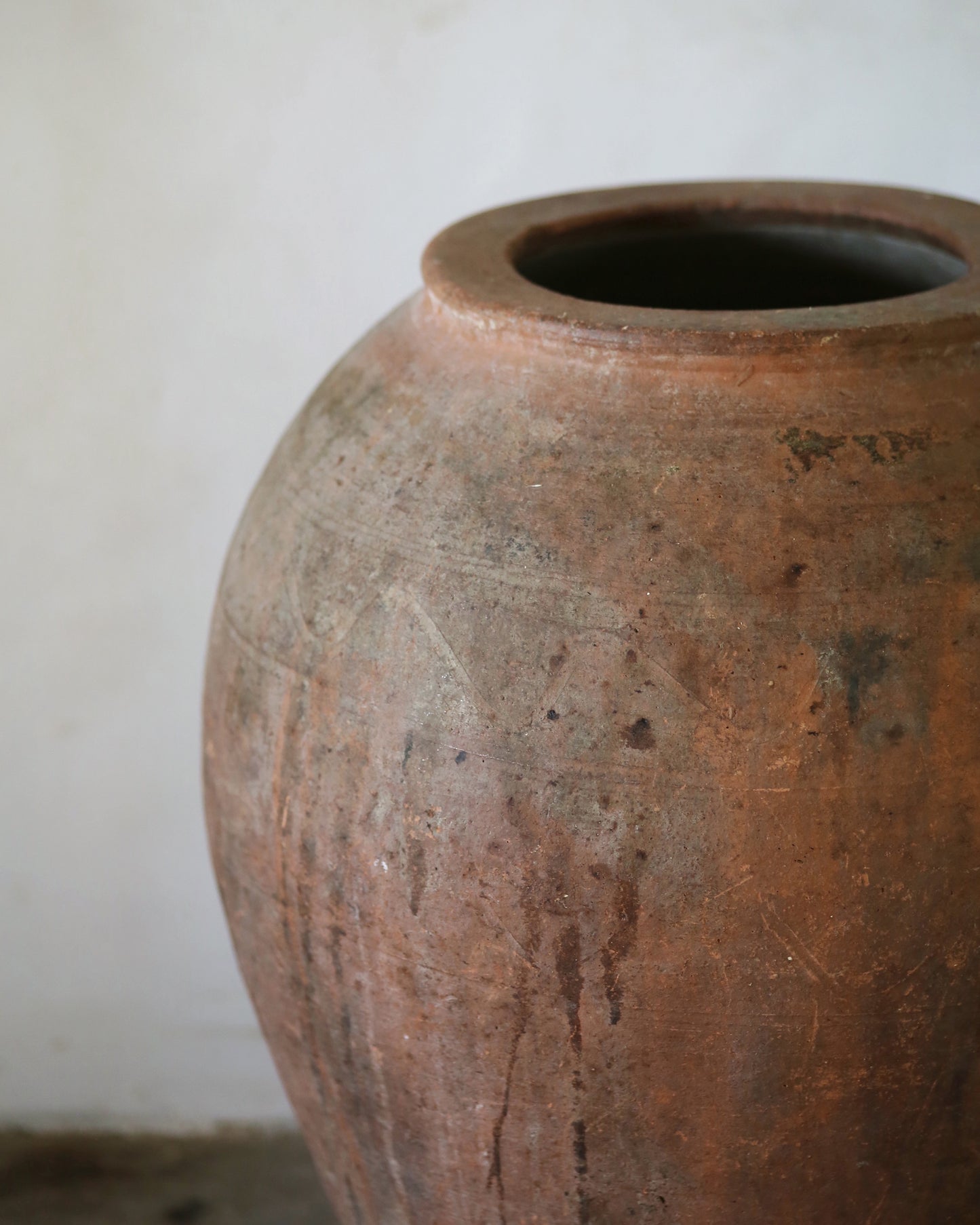 Brown ceramic vase with textured surface on a plain background