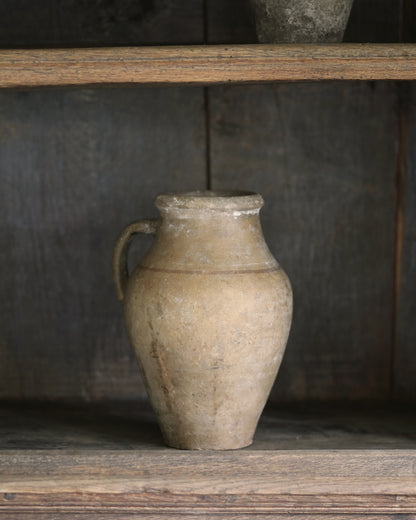 Vintage-style ceramic pitcher pot styled on an antique wooden bookcase