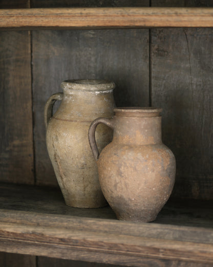 Two rustic clay Turkish pots styled on a wooden shelf 