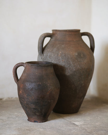 Two rustic clay pots on a neutral background