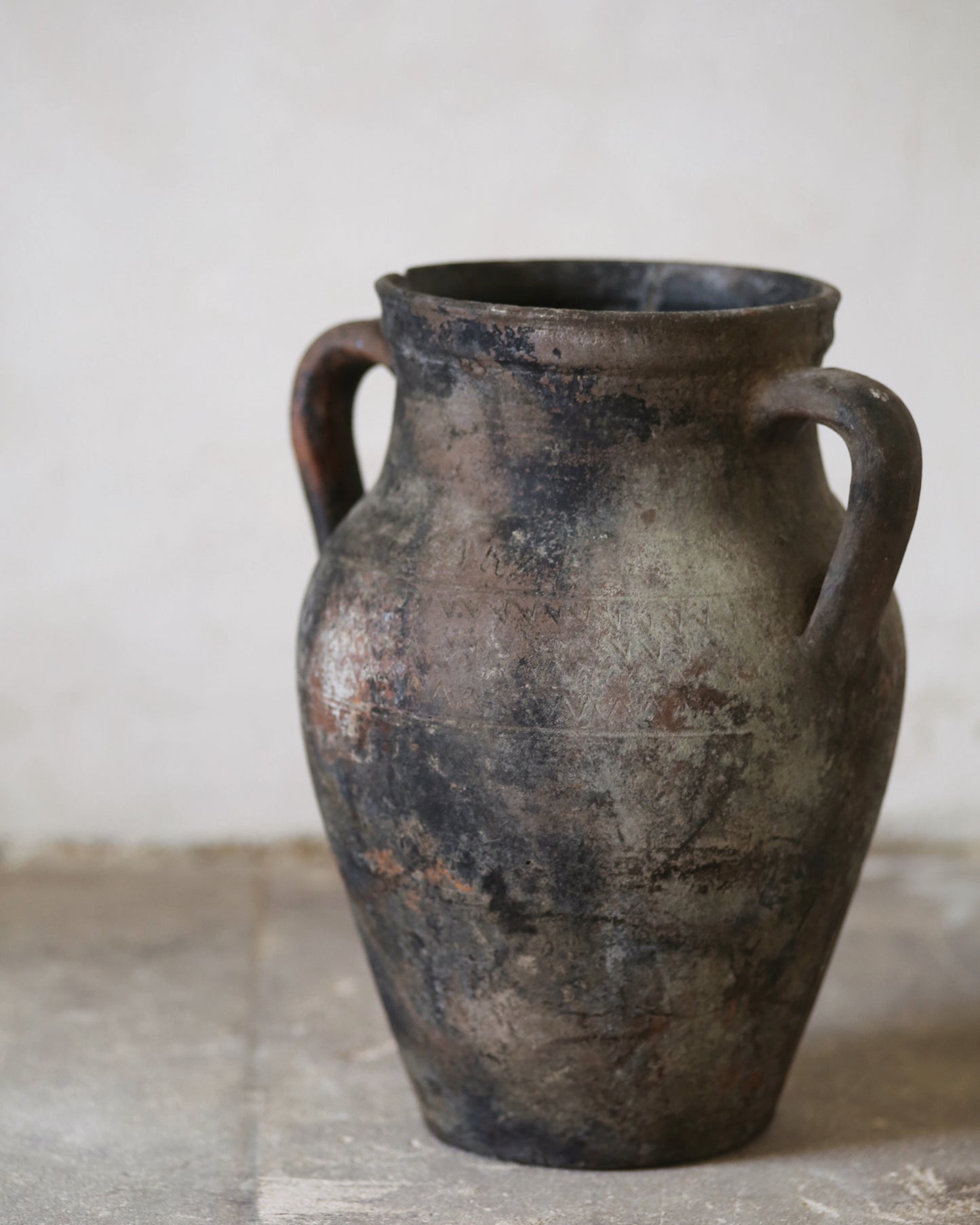 Vintage terracotta vase with two handles on a neutral background