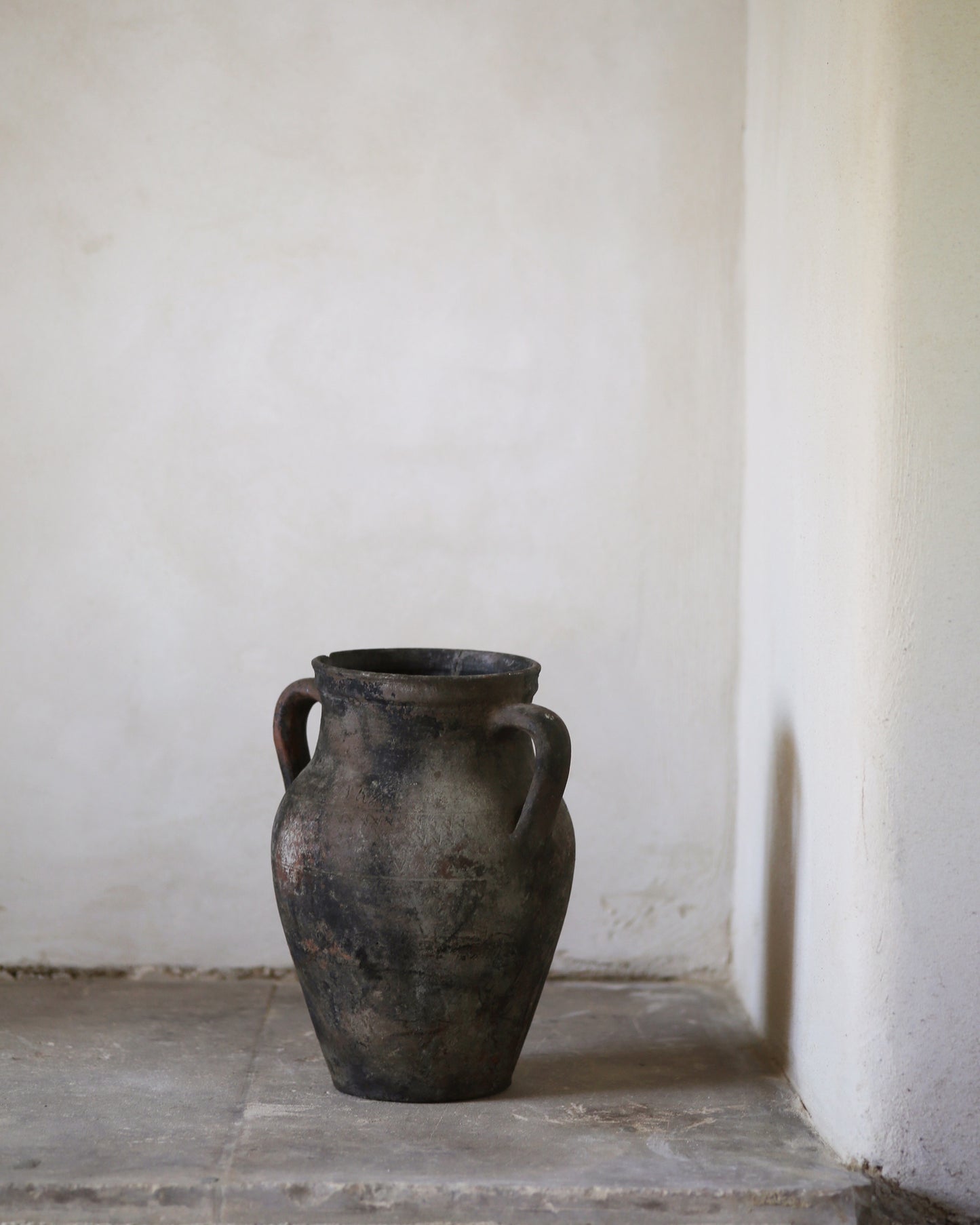 Vintage terracotta vase against a plain white wall