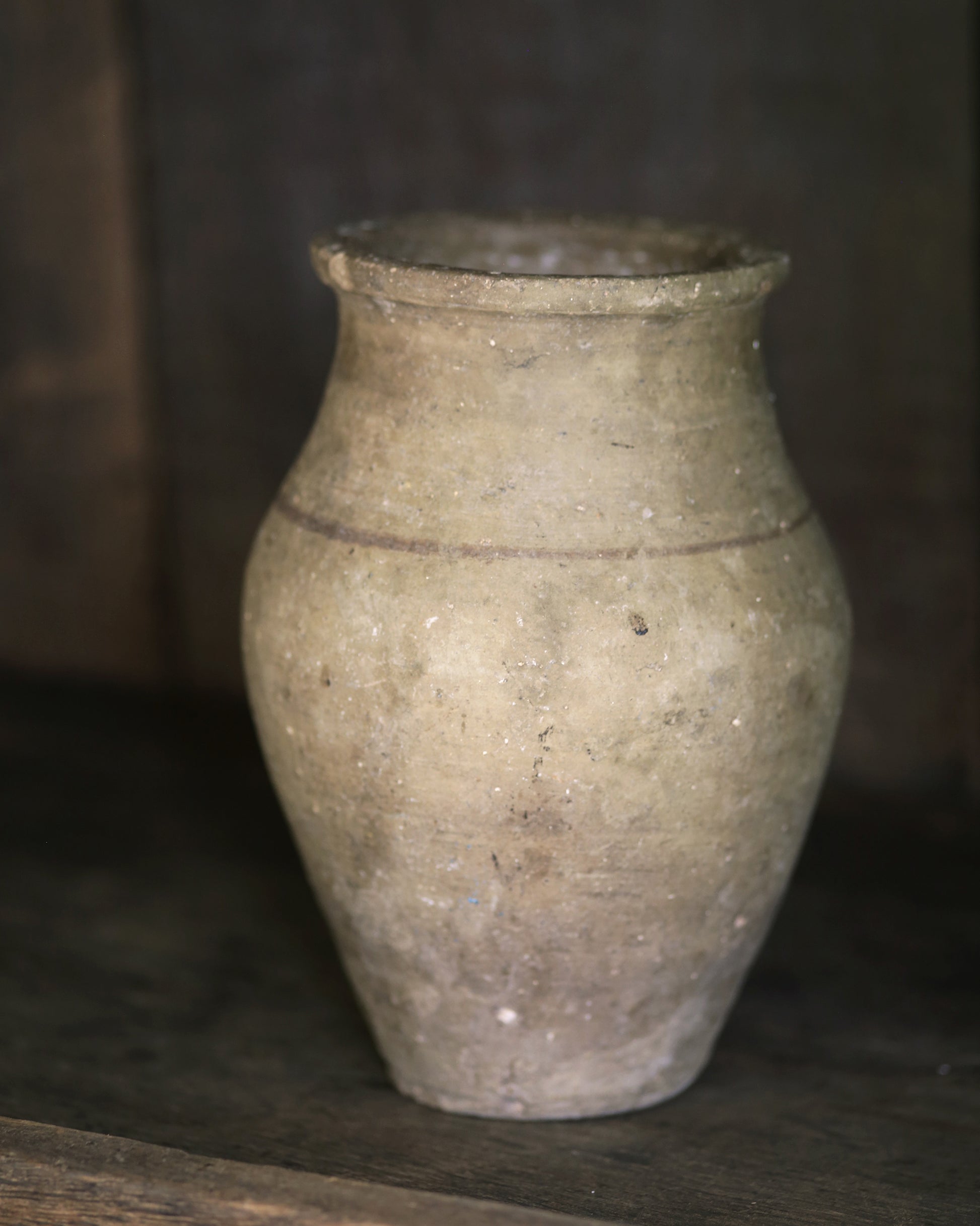 Rustic antique pale pottery sat on a wooden shelf