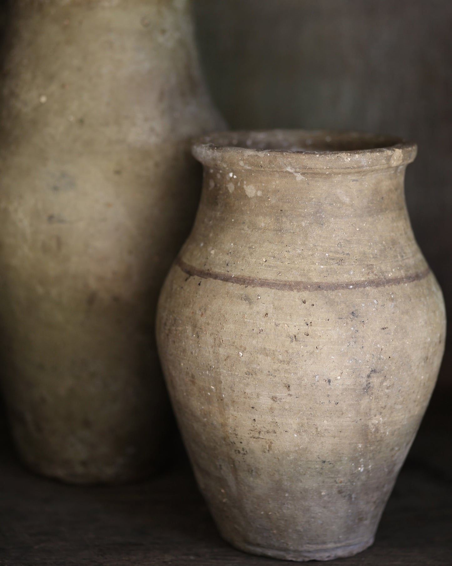 Two rustic clay pots with a dark background
