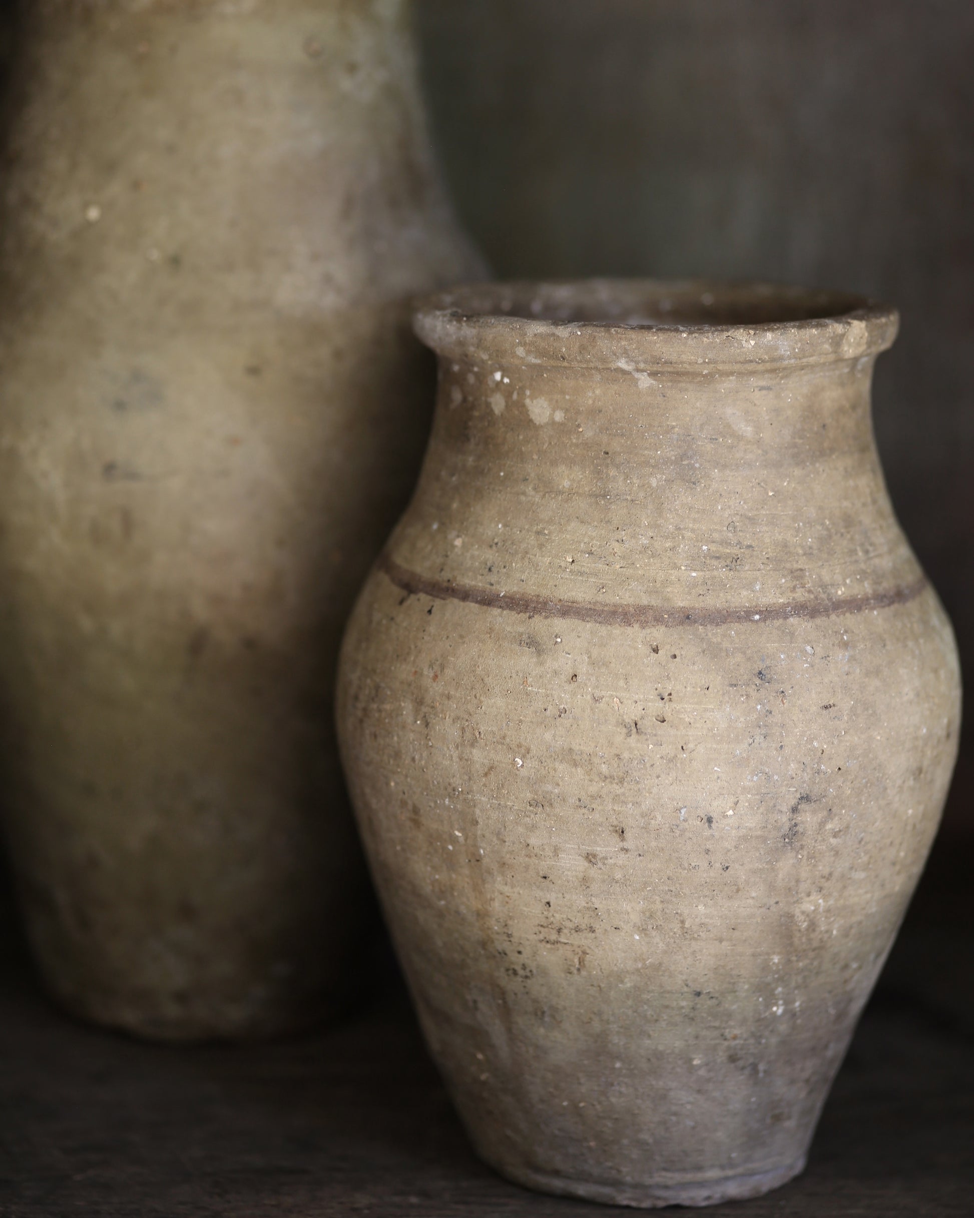Two rustic clay pots with a dark background