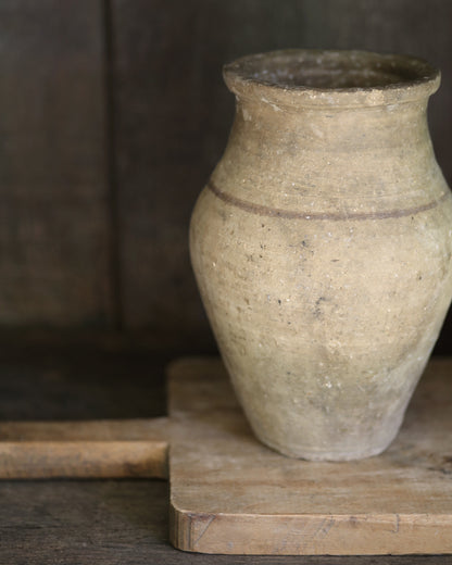 Vintage terracotta pot on a vintage wooden breadboard