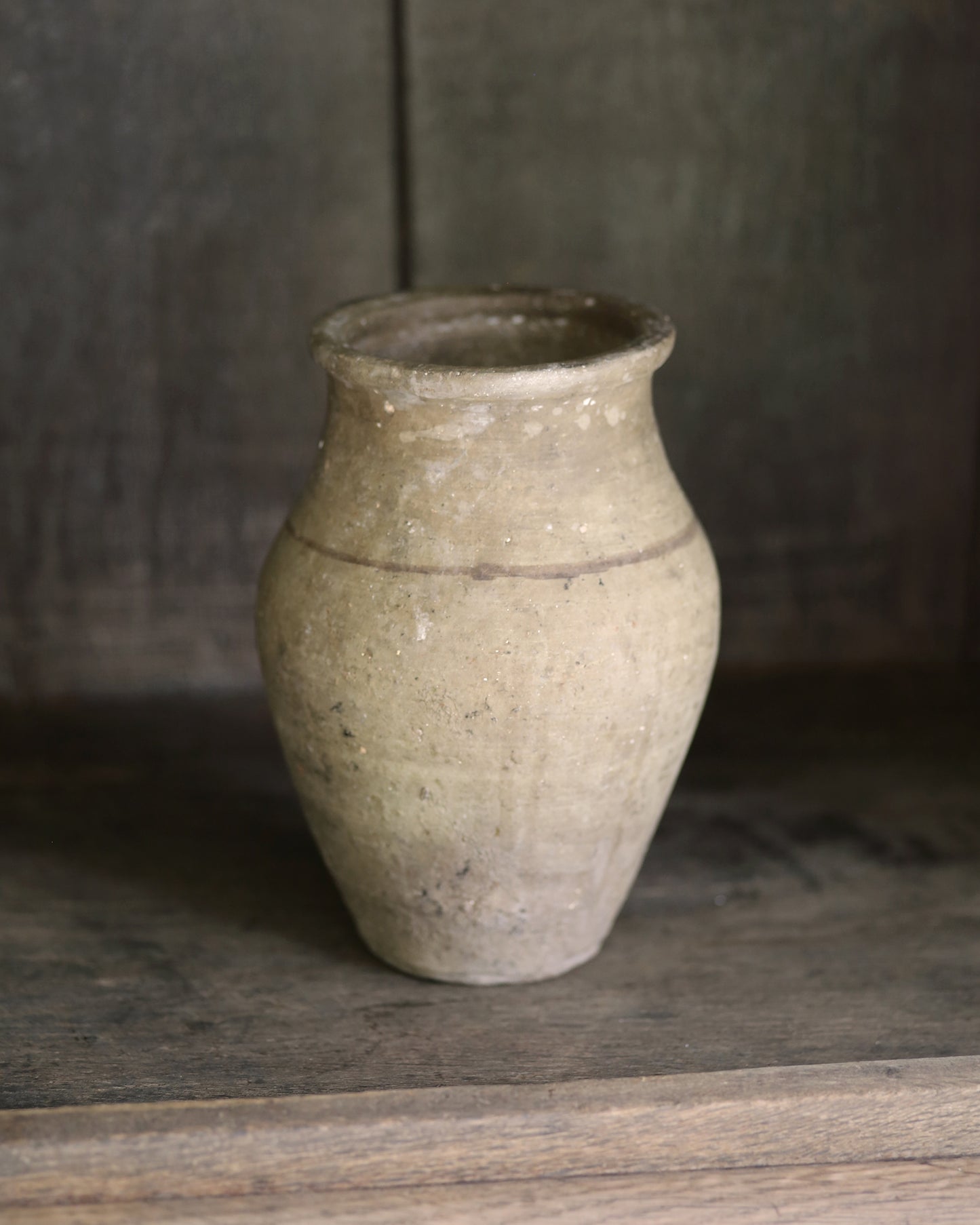 Vintage ceramic vase on a wooden bookcase