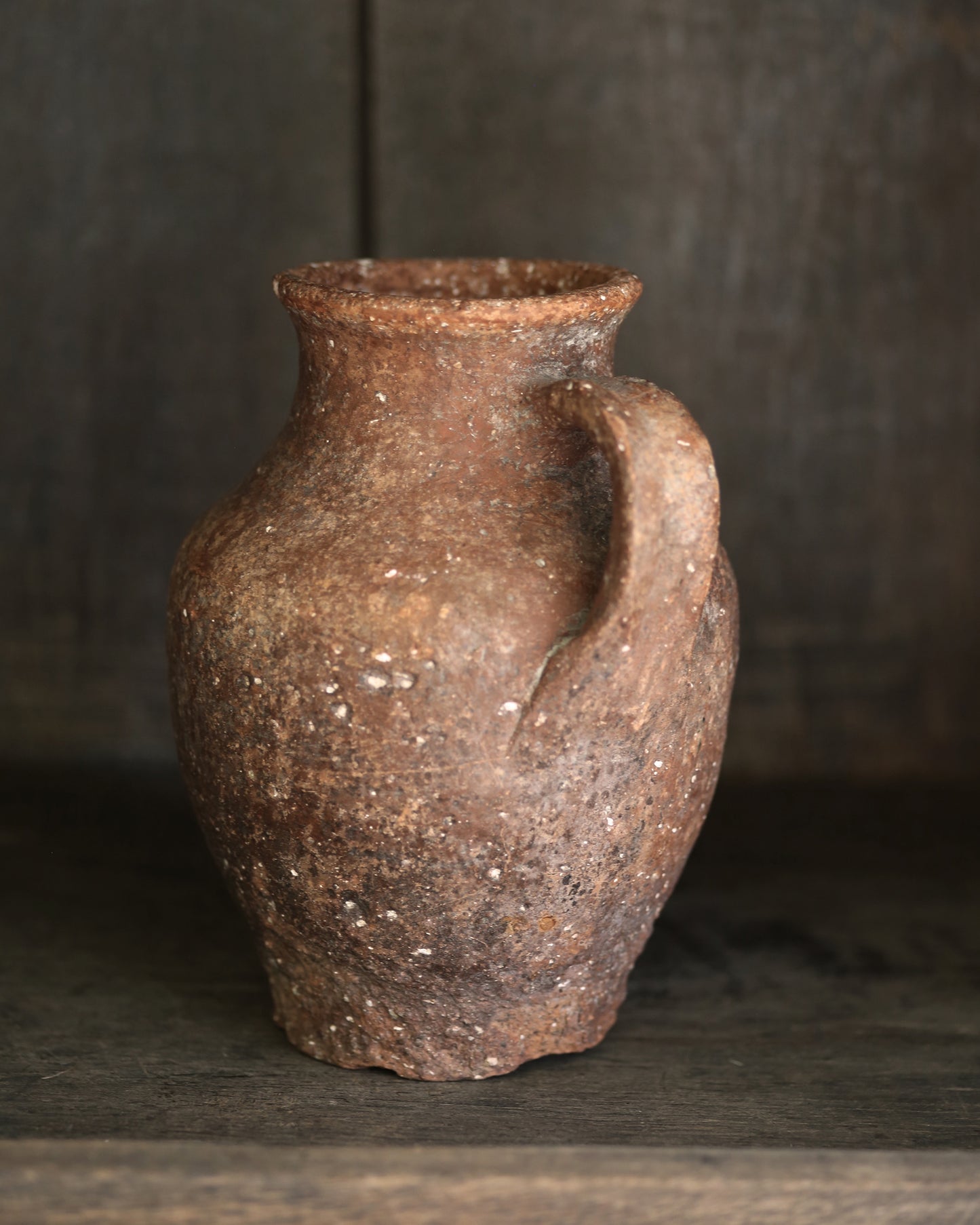 Antique terracotta ceramic pitcher pottery on a dark background
