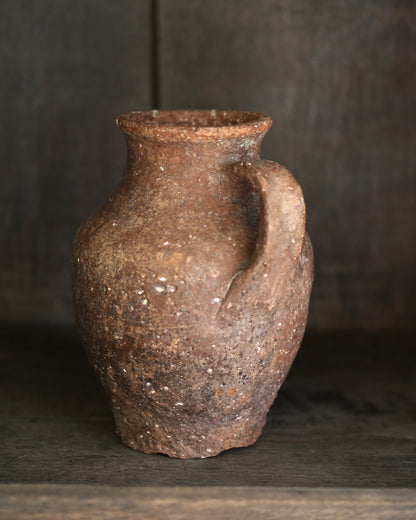 Antique terracotta ceramic pitcher pottery on a dark background