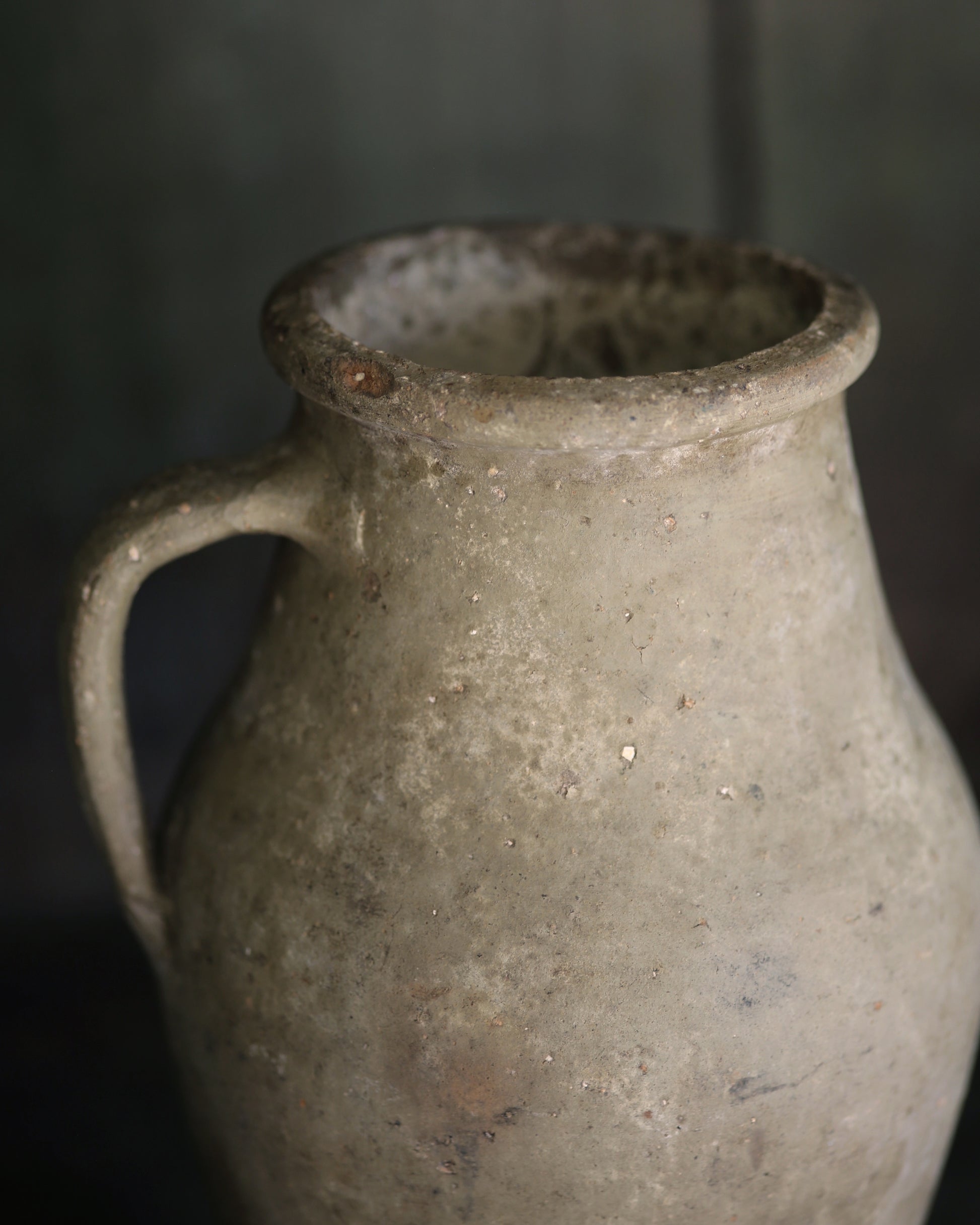 Vintage ceramic pitcher with a dark background
