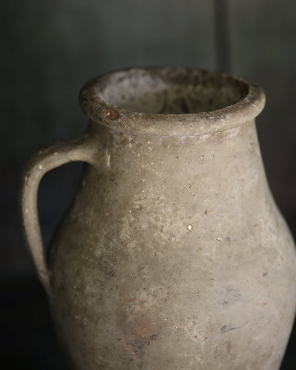Vintage ceramic pitcher with a dark background