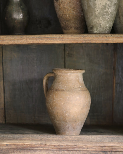 Vintage rustic terracotta vases on an antique wooden bookcase