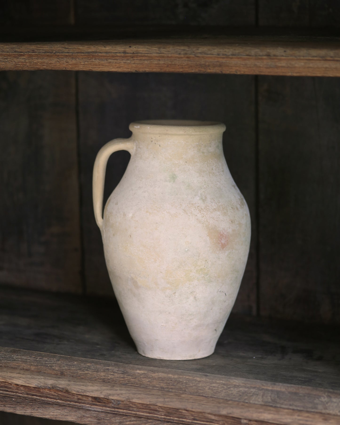 White ceramic pitcher on a wooden shelf