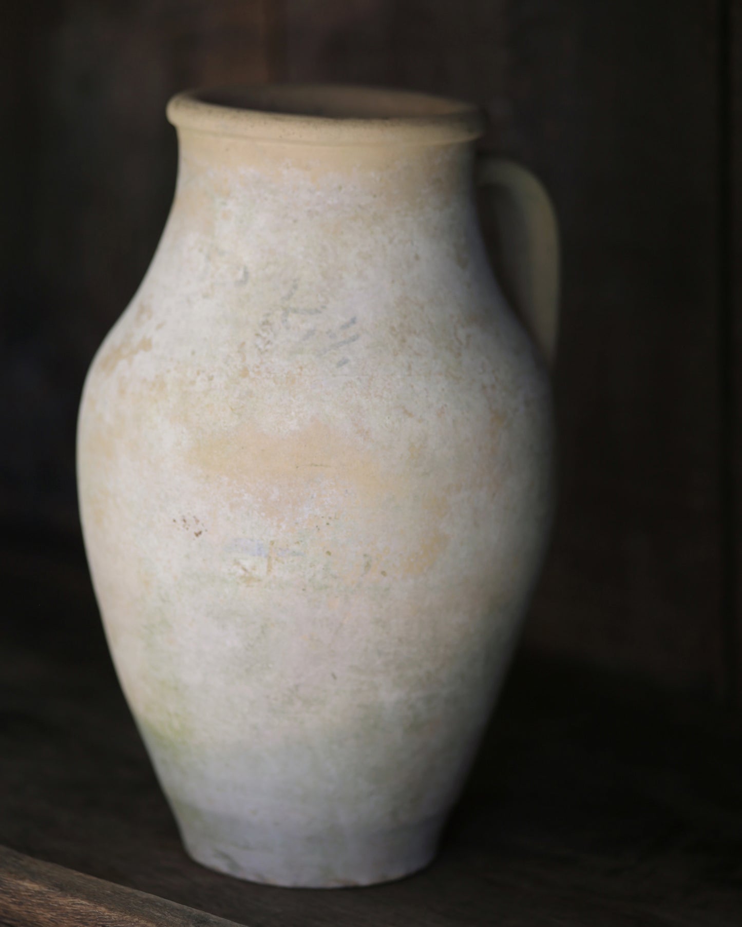 Whitewash surface terracotta pottery vase sat on a elm shelf