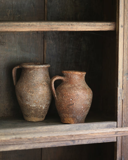 Two rustic clay pots on a dark wooden antique elm bookcase