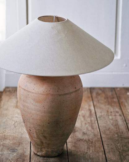 Antique clay urn table lamp base pictured with large linen shade