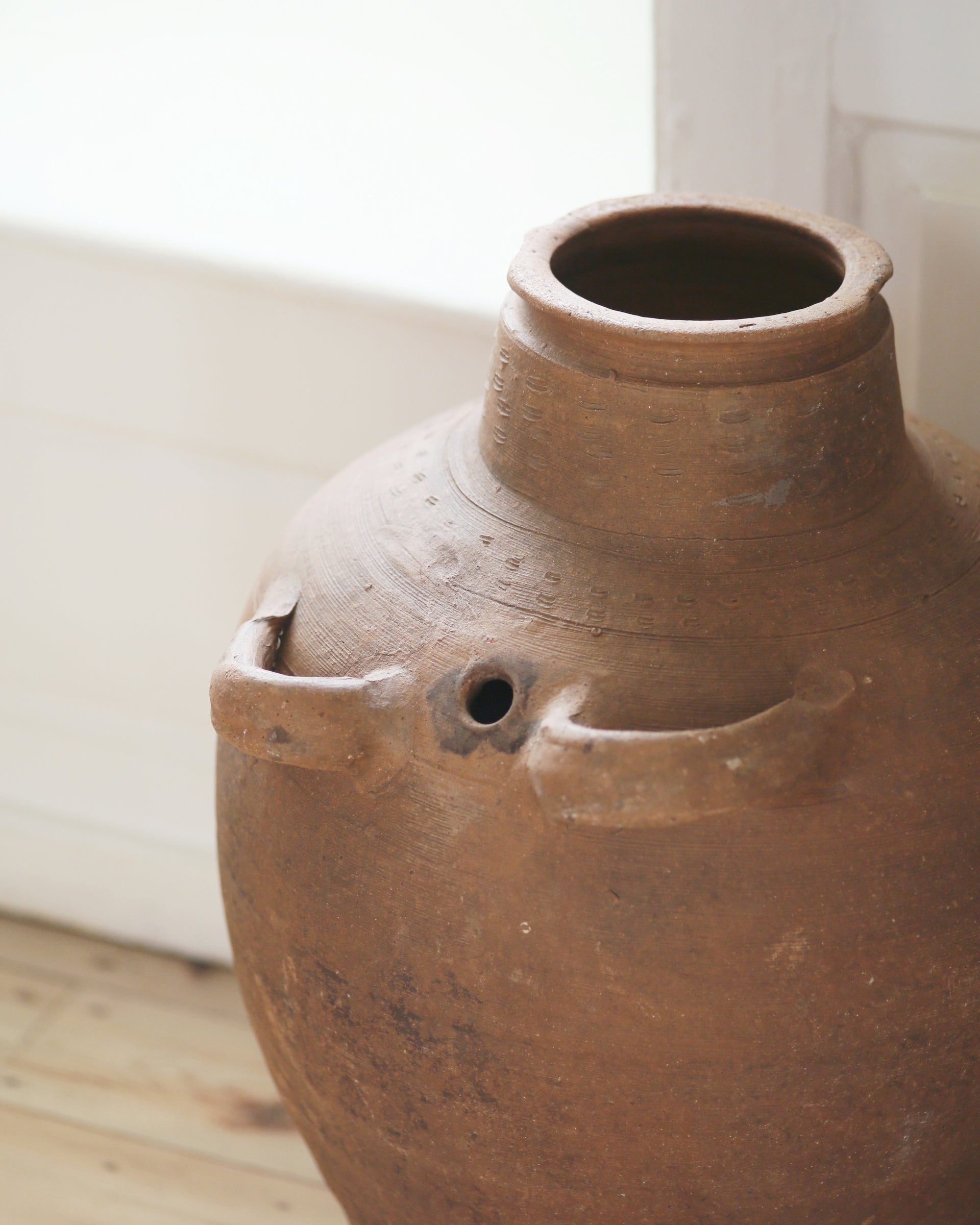 Handmade artisanal detail on top of vintage terracotta olive pot