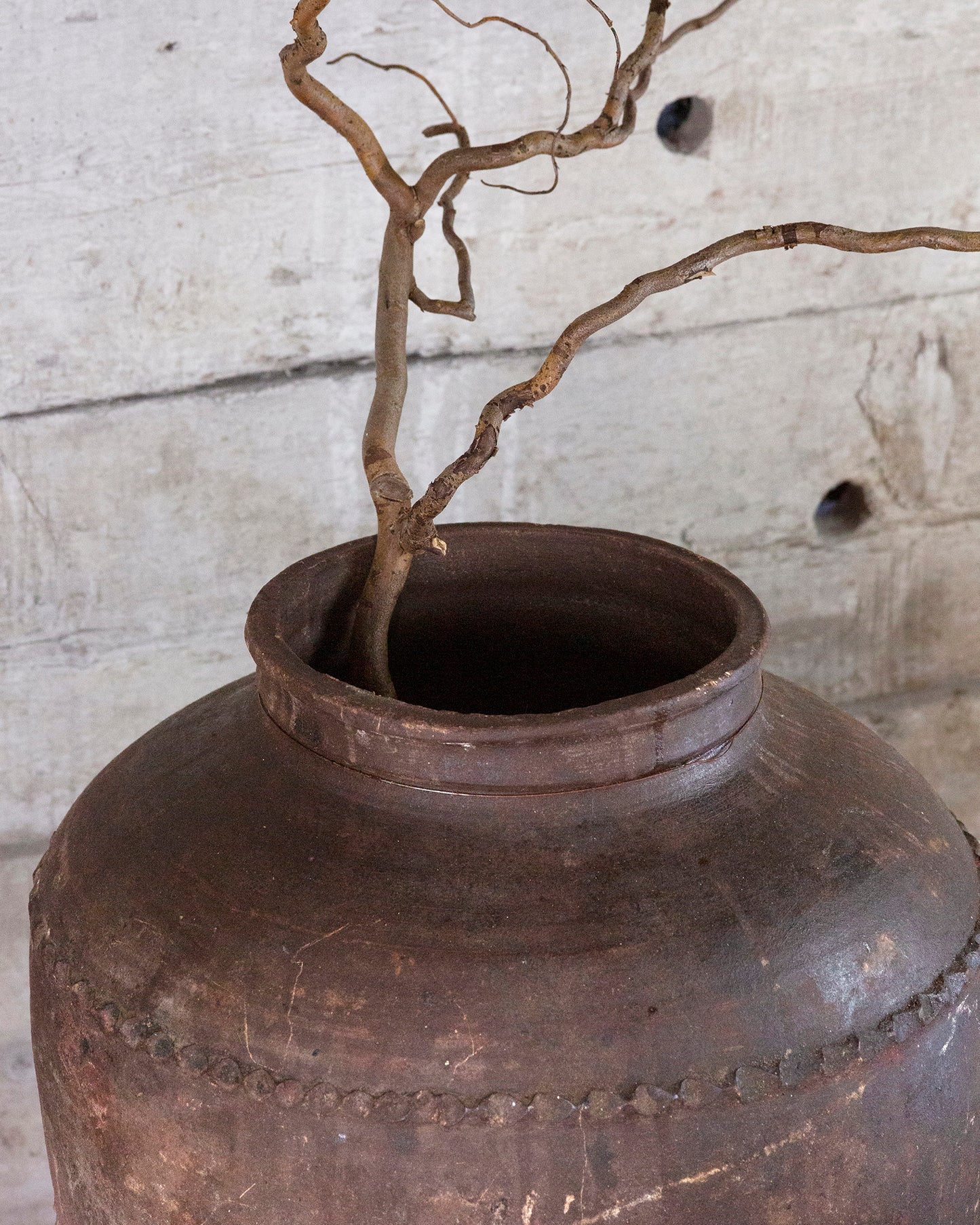 Close up of olive pot styled with twigs