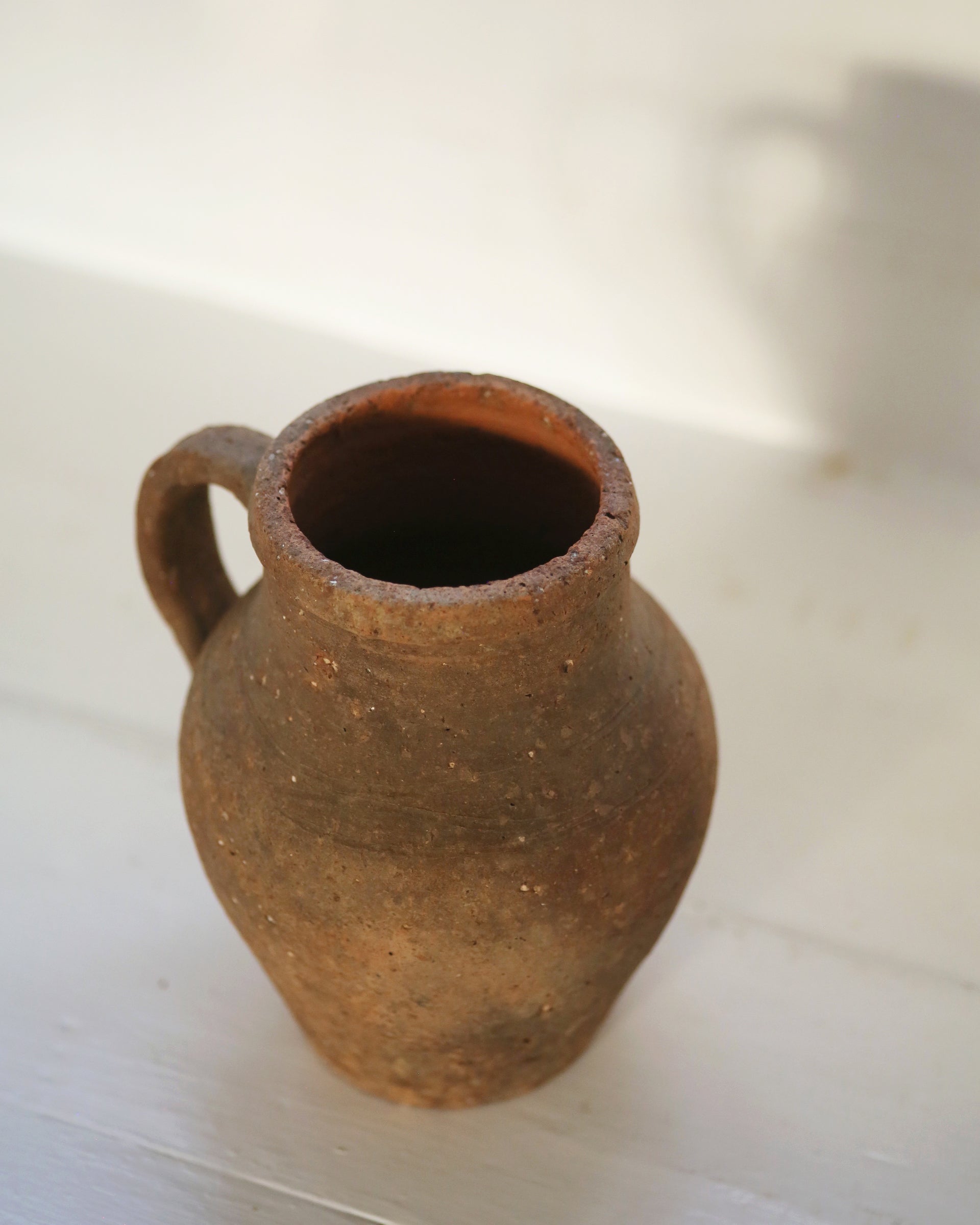 Small, textured terracotta antique pitcher jug