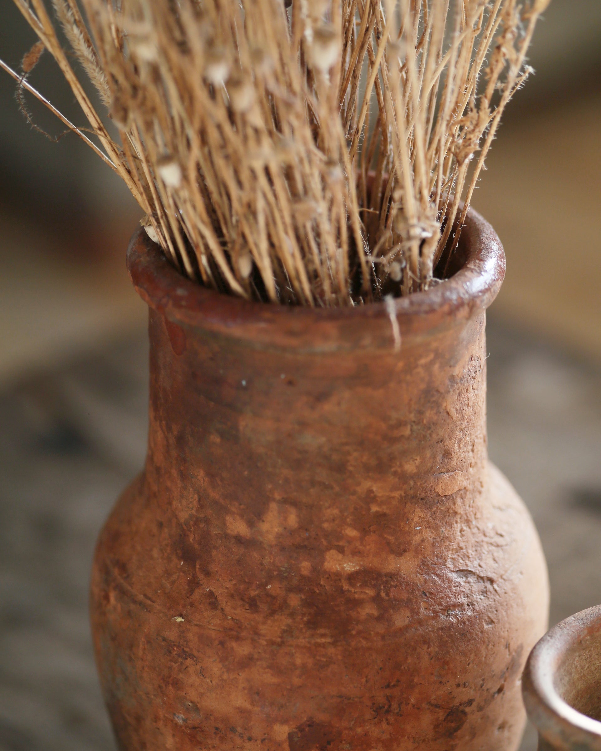 Turkish terracotta vase with authentic texture, filled with dried flowers 