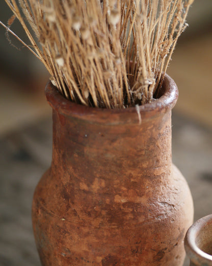 Turkish terracotta vase with authentic texture, filled with dried flowers 