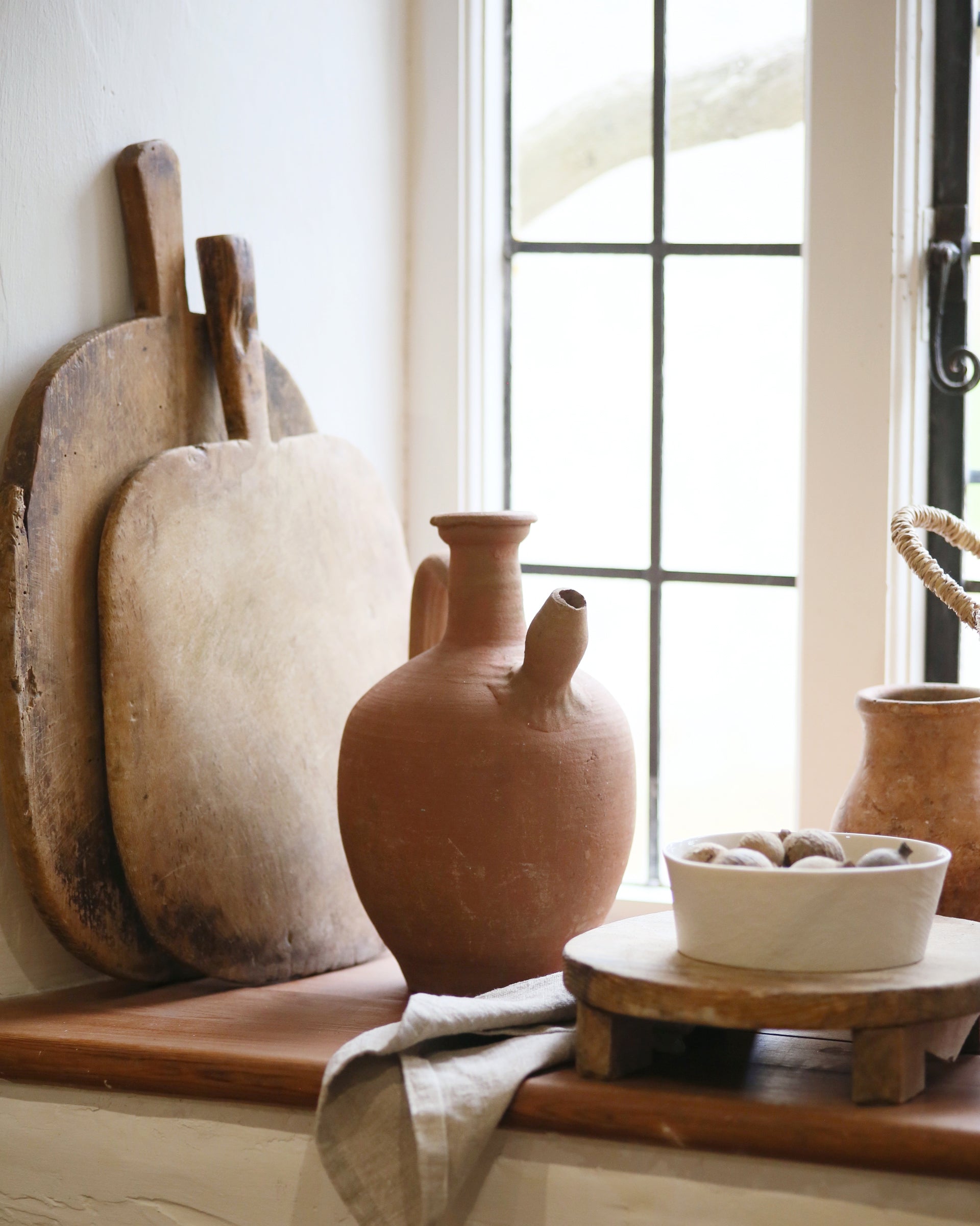 Kitchen window display showing antique terracotta water pitcher jug