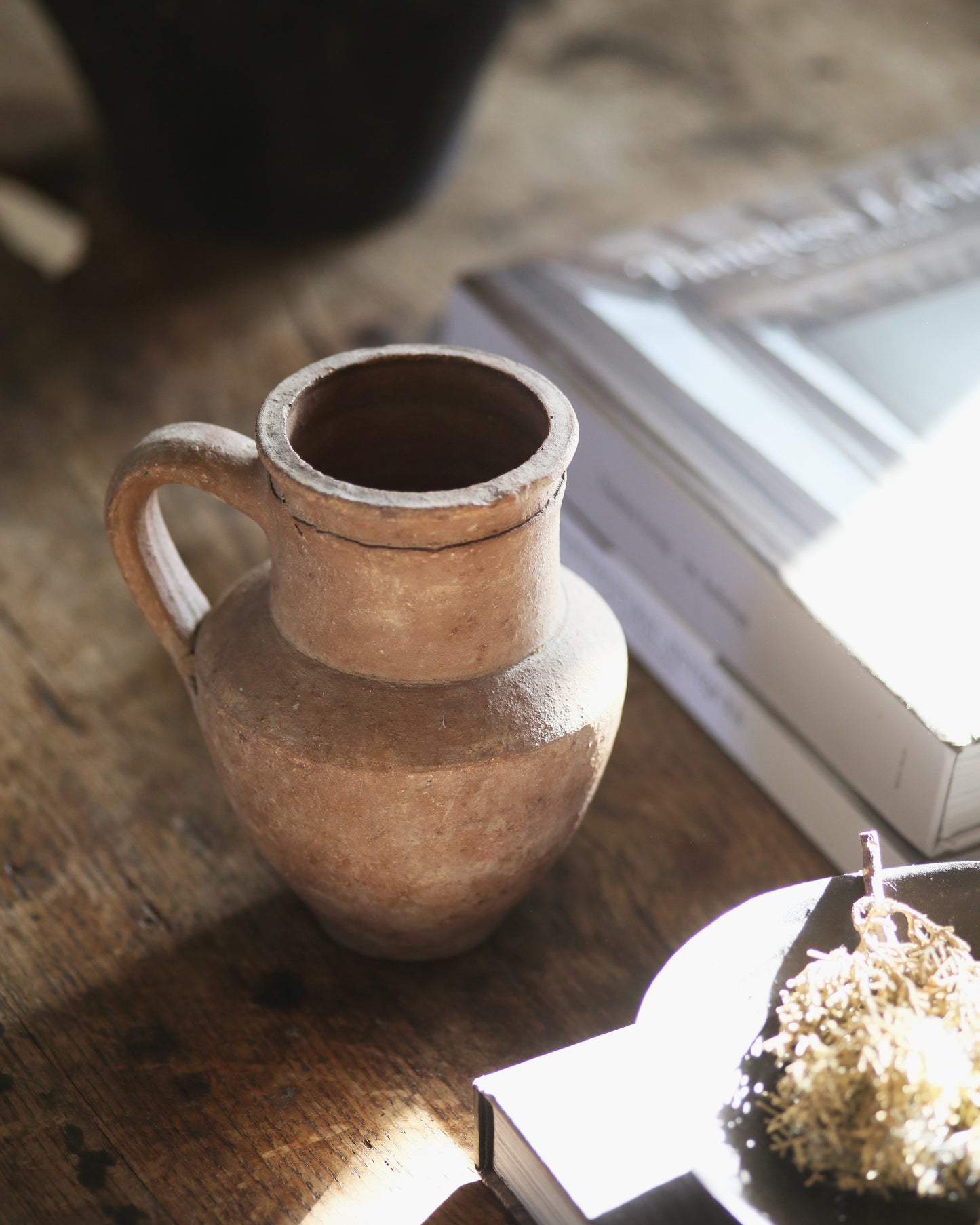 Small brown pitcher style rustic pot on coffee table