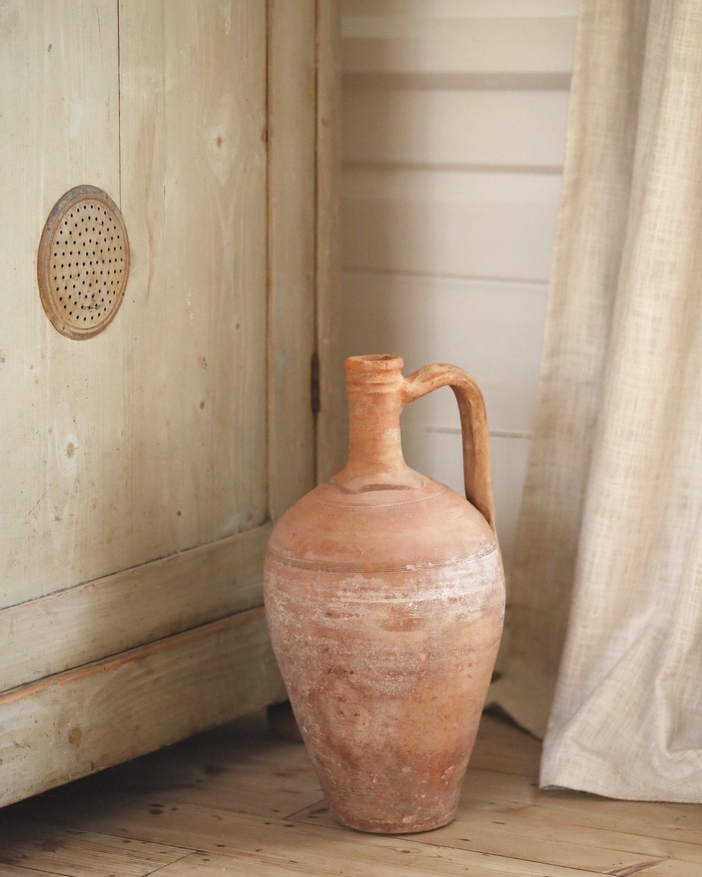 Large terracotta pot with single handle and narrow neck