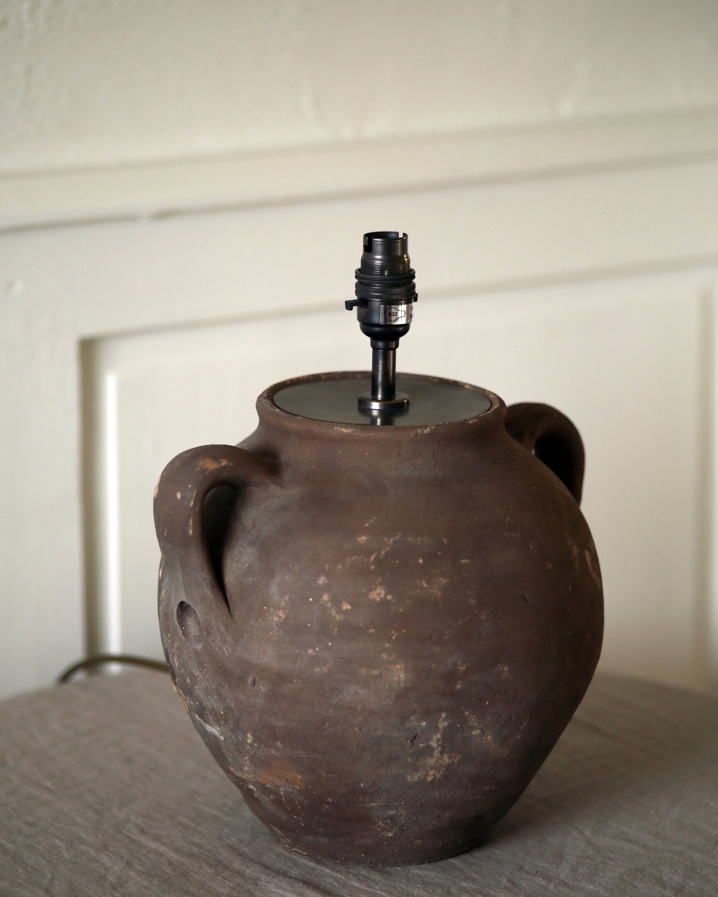 Rustic aged patina and handle detail of clay pottery lamp base