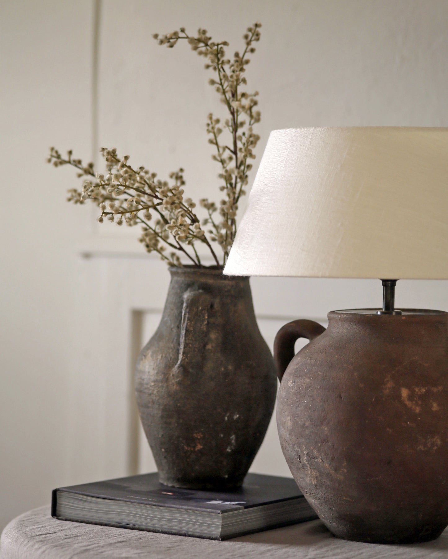 Antique clay lamp styled with linen shade and antique pot