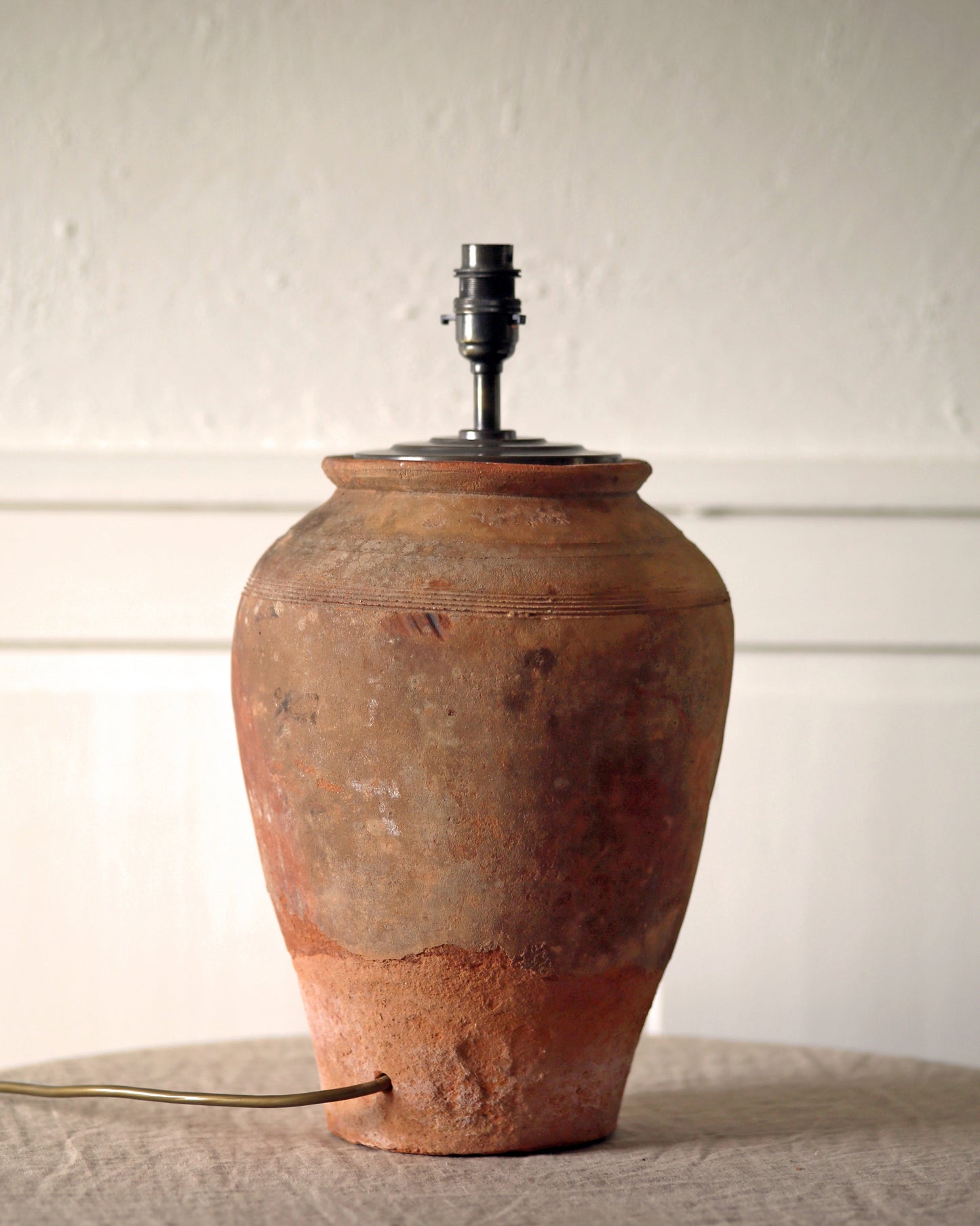 Rustic texture and patina of aged terracotta stone lamp base 