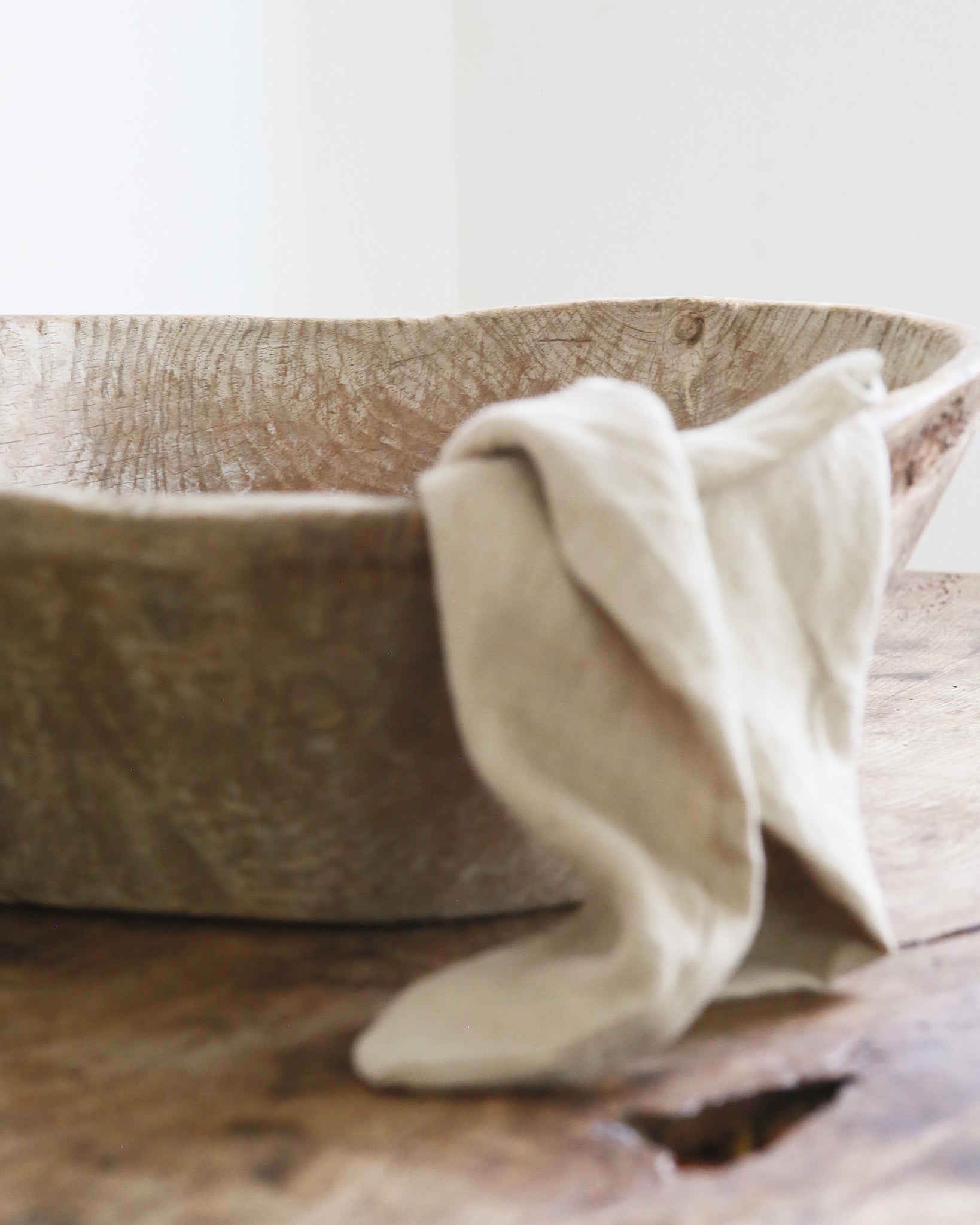 Rustic wooden dough bowl with tea towel