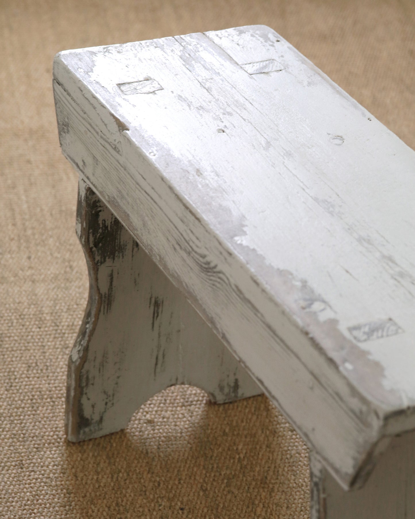 Close up finish of white weathered wood milking stool