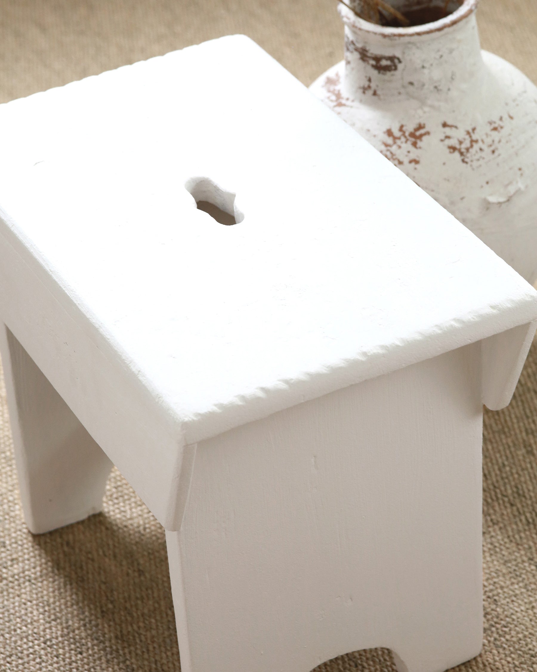 Detail on chalk white painted wooden milking stool